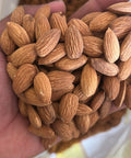 Hand holding a handful of almonds with a blurred background